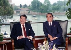 FILE - U.S. President Ronald Reagan, left, and Japanese Prime Minister Yasuhiro Nakasone attend their meeting at the Cipriani Hotel, in Venice, June 8, 1987.