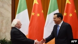 FILE - Ireland President Michael Higgins is greeted by Chinese Premier Li Keqiang in Beijing's Great Hall of the People on Dec. 10, 2014. Higgins was on a state visit to China.