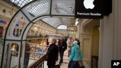 FILE - customers walk at an Apple Premium reseller inside the Moscow GUM State Department store in Moscow, Russia, Nov. 28, 2014.