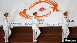 FILE - Soldiers carry the flag of the Olympic Council of Asia during an opening ceremony.