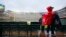 Baseball fans wait out a rain delay before a baseball game between the Oakland Athletics and the Texas Rangers, April 13, 2019, in Arlington, Texas. Tornadoes from the storm system left two children dead and several other people injured.