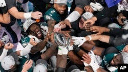 Philadelphia Eagles players celebrate with the Vince Lombardi Trophy after the Eagles won the NFL Super Bowl 59 football game against the Kansas City Chiefs, Feb. 9, 2025, in New Orleans.