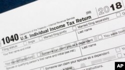 FILE- This July 24, 2018, photo shows a portion of the 1040 U.S. Individual Income Tax Return form for 2018 in New York.