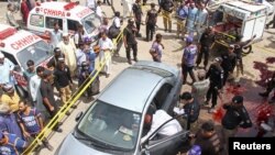 Police officers inspect a car after unidentified gunmen carried out an attack on a prominent Pakistani cleric in Karachi, Pakistan, March 22, 2019.