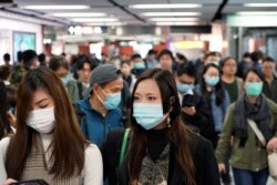 Passengers wear masks to prevent an outbreak of a new coronavirus in a subway station, in Hong Kong, Jan. 22, 2020.