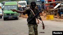 A mutinying soldier gestures as he stands guard at the checkpoint of the entrance of Bouake, Ivory Coast, May 15, 2017. 