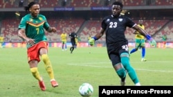 FILE - Cameroon's Clinton Njie (L) vies for the ball with Rwanda's goalkeeper Oliver Kwizera (R) during a African Cup of Nations (AFCON) qualifying match between Cameroon and Rwanda, at Stade Omnisport, in Douala, Cameroon, March 30, 2021.