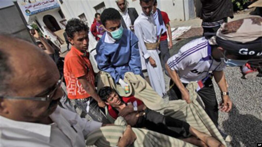 Anti-government protesters carry an injured an injured person into the yard of a Mosque for help following clashes with Yemeni police in Sana'a, Yemen, March 12, 2011