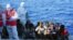 FILE - Migrants are evacuated by Italian Coast guards from the Open Arms Spanish humanitarian boat at the coasts of the Sicilian island of Lampedusa, southern Italy, Aug. 17, 2019. 