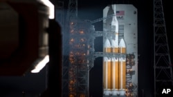 This NASA image shows the agency's Orion spacecraft mounted on a United Launch Alliance Delta IV Heavy rocket, with a mobile service tower rolling back, Dec. 4, 2014.