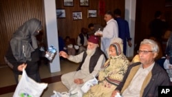 Passengers rescued by security forces from a passenger train attacked by insurgents, receive water bottles upon their arrival at a railway station in Quetta, Pakistan, March 12, 2025.