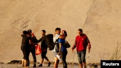 Migrantes venezolanos que buscan asilo cruzan el río Bravo para entregarse a los agentes de la Patrulla Fronteriza de los EEUU, en Ciudad Juárez, México, el 6 de octubre de 2022. REUTERS/José Luis González
