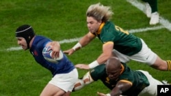 FILE - France's Antoine Dupont, left, challenges for the ball during the Rugby World Cup quarterfinal match between France and South Africa at the Stade de France in Saint-Denis, near Paris, Sunday, Oct. 15, 2023.