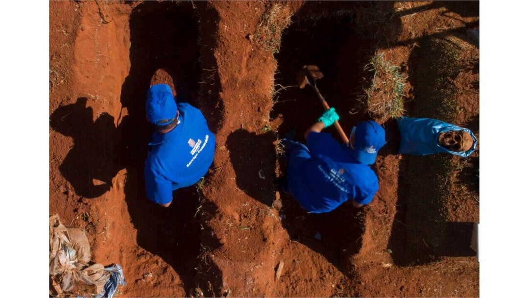Cemetery workers exhume remains buried three years ago at the Vila Formosa cemetery, June 12, 2020. They're making room for COVID-19 victims.