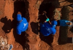 Cemetery workers exhume remains buried three years ago at the Vila Formosa cemetery, June 12, 2020. They're making room for COVID-19 victims.