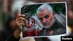 An Iranian holds a picture of late General Qassem Soleimani, head of the elite Quds Force, who was killed in an air strike at Baghdad airport, as people gather to mourn him in Tehran, Iran January 4, 2020.