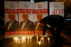 FILE - An man lights a candle during a candlelight vigil for Saudi journalist Jamal Khashoggi outside Saudi Arabia's consulate in Istanbul, Turkey, Oct. 25, 2018.