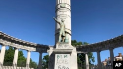 A monument to Confederate President Jefferson Davis in Richmond, Va., is covered with graffiti on Sunday, May 31, 2020, after overnight protests over the death of George Floyd.