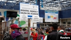 Ciudadanos venezolanos y otros migrantes esperan en la frontera con Colombia, en el puesto de control del puente de Rumichaca, en Ecuador, 24 de agosto de 2019.