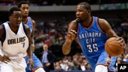 Kevin Durant (35) d'Oklahoma City à droite, tente un drible devant Al-Farouq Aminu (7) de Dallas Mavericks au cours de la prmière mi-temps d'un match de basketball, vendredi 10 octobre 2014, à Dallas, Texas