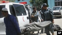 The lifeless body of a police officer is carried from an ambulance at the hospital in Ghazni, west of Kabul, Afghanistan, June 22, 2011.