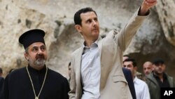 Presiden Suriah Bashar al-Assad (kanan) saat mengunjungi Desa Kristen Maaloula, dekat Damaskus (20/4). Assad diperkirakan akan menang mudah dalam Pilpres 3 Juni mendatang. 