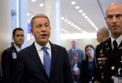 FILE - In this Wednesday, June 26, 2019 file photo, Turkish Defense Minister Hulusi Akar, center left, arrives to NATO headquarters in Brussels.