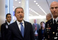 FILE - In this June 26, 2019 file photo, Turkish Defense Minister Hulusi Akar, center left, arrives to NATO headquarters in Brussels.