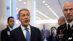 FILE - Turkish Defense Minister Hulusi Akar, center left, arrives to NATO headquarters in Brussels, June 26, 2019. Turkey's defense ministry said will retaliate against attacks on Turkish vessels and interests by the forces of Libya's Khalifa Hifter.