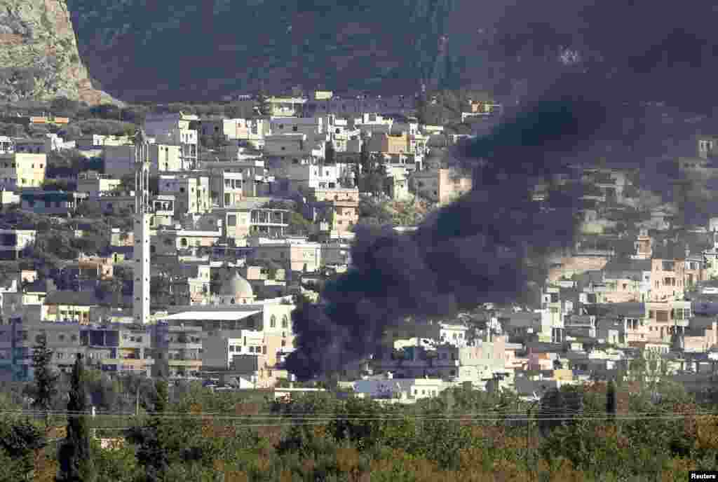 Smoke, caused by mortar bombs and gunfire during clashes between the Syrian Army and rebels, rises from the Syrian border town of Haram as seen from the Turkish-Syrian border near the town of Reyhanli in Hatay province October 19, 2012.