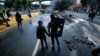 FILE - A couple hold hands at a roadblock set by anti-government protesters in Caracas, Venezuela, April 24, 2017. Many young people who once joined such demonstrations are now disillusioned and are considering emigrating – and it’s wreaking havoc on the country’s dating scene. 