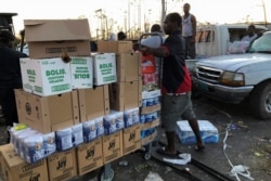 A man carries boxes outside a looted supermarket after Hurricane Dorian hit the Abaco Islands in Marsh Harbour, Bahamas, Sept. 5, 2019.