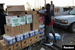 A man carries boxes outside a looted supermarket after Hurricane Dorian hit the Abaco Islands in Marsh Harbour, Bahamas, Sept. 5, 2019.