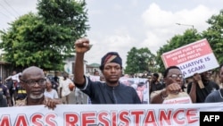 FILE —A protestor raises his fist during the Joint Action Front and the Coalition for Revolution nationwide protest against the government policies of Nigerian President Bola Tinubu in Lagos on February 26, 2024. 