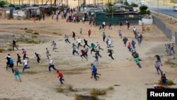 Protesters flee as police open fire during a farm workers strike at De Doorns, on the N1 highway linking Cape Town and Johannesburg, January 9, 2013. 