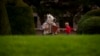 A child runs by a person wearing a horse mask and playing an accordion in the Maria Theresien Platz in Vienna, Austria, Sept. 28, 2024. 