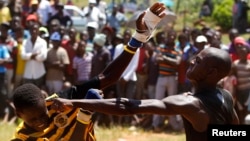 FILE - Fist fighters battle during the Musangwe, an age old tradition where men and boys display their fighting skills, at Gaba Village in Limpopo province, South Africa. 