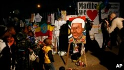 Children and their families stand outside the Mediclinic Heart Hospital where former South African President Nelson Mandela is being treated in Pretoria, South Africa, June 26, 2013.