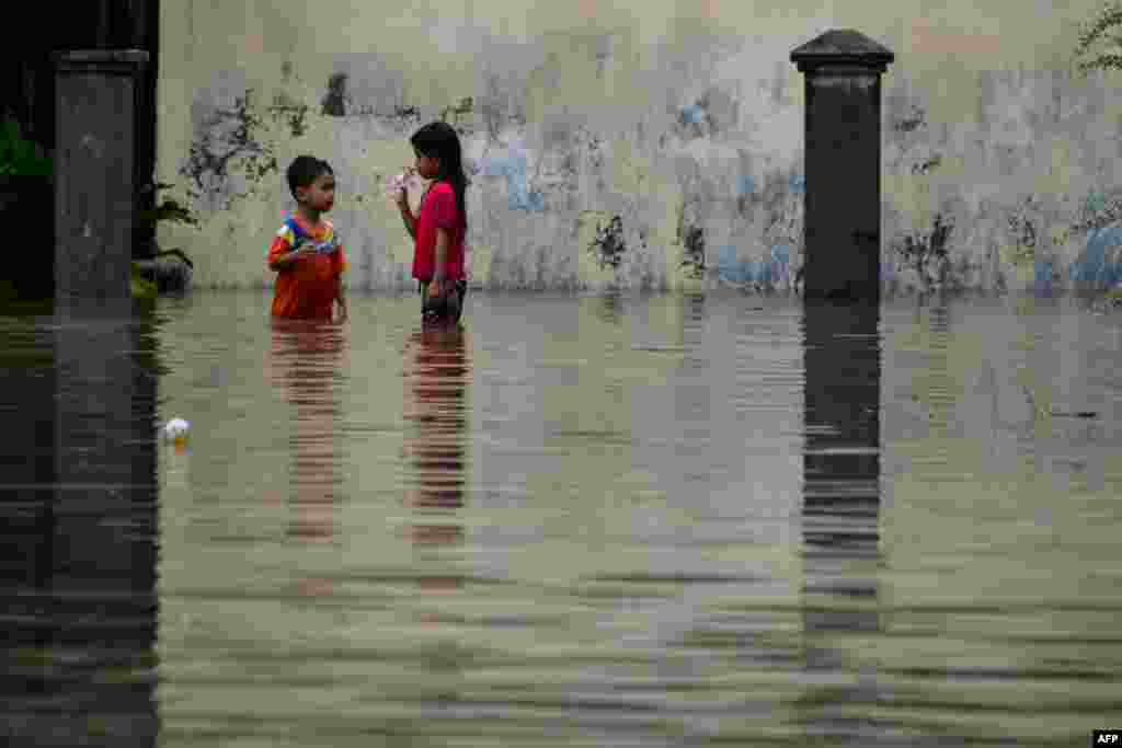 Children stand in floodwaters following heavy rain in the residential area of Ajun on the outskirts of Banda Aceh, Indonesia.