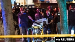 Police officers help remove the the body of a man who was shot dead, amid weekend street clashes between supporters of President Donald Trump and counter-demonstrators in Portland.