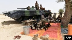 Les soldats tchadiens prient à côté d'un véhicule blindé près de Malam Fatori, Nigeria, 3 avril 2015.