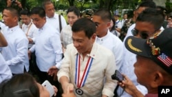 Philippine President Rodrigo Duterte poses is greeted by supporters following a wreath-laying ceremony in observance of National Heroes Day Monday, Aug. 29, 2016 at the Heroes Cemetery in suburban Taguig city east of Manila, Philippines. 