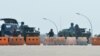 Soldiers stand guard on a blockaded road to Myanmar's parliament in Naypyidaw on February 1, 2021, after the military detained the country's de facto leader Aung San Suu Kyi and the country's president in a coup. (Photo by STRINGER / AFP)