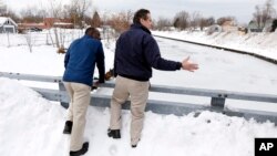 El gobernador de Nueva York, Andrew Cuomo (derecha), y el alcalde de Buffalo, Byron Brown observan la limpieza de la quebrada Cazenovia en el sur de la ciudad, que se prepara para posibles inundaciones.
