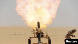 A Saudi soldier fires a mortar toward Houthi positions at the Saudi border with Yemen, April 21, 2015. 