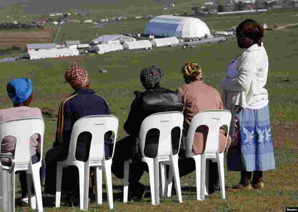 Local women sit at a public viewing point near the burial ground of Nelson Mandela ahead of his funeral in Qunu, Dec. 15, 2013.&nbsp;