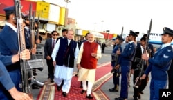 In this photo released by Press Information Department, India's Prime Minister Narendra Modi, right, reviews guard of honor with his Pakistani counterpart, Nawaz Sharif, in Lahore, Pakistan, Dec. 25, 2015.