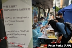 Para pekerja migran mendaftar tes COVID-19 di distrik Central, Hong Kong, Sabtu, 1 Mei 2021. (Foto: Peter Parks/AFP)