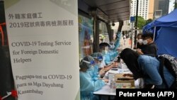 Para pekerja migran mendaftar tes COVID-19 di distrik Central, Hong Kong, Sabtu, 1 Mei 2021. (Foto: Peter Parks/AFP) 