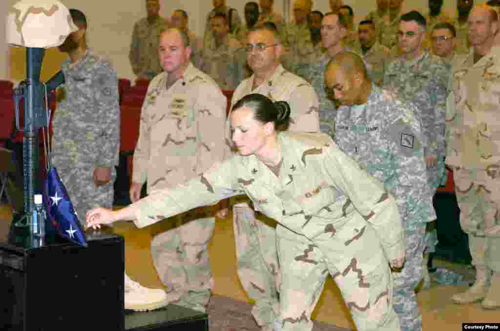 Petty Officer 2nd Class Jaclyn King, of Kailua, Hawaii, places a coin on a “fallen comrade” display for Petty Officer 1st Class Victor Jeffries during a memorial service held in a chapel at Camp Arifjan, Kuwait, Jan. 5. Jeffries, 52, from Honolulu, died D